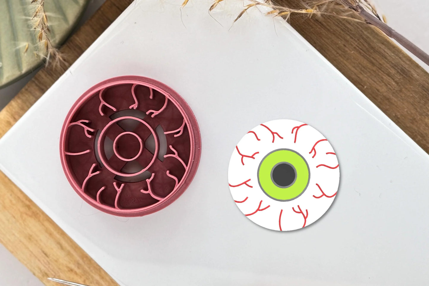 Bloodshot eyeball shaped clay cutter with vein, iris and pupil stamp imprint lines.