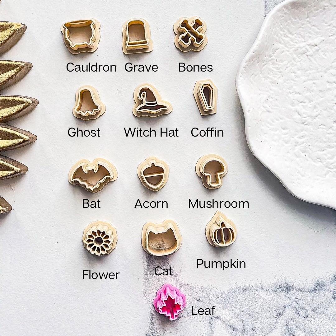 Halloween clay cutters all with text description to easily match up with the selection drop down. beige and pink cutters on marble background.