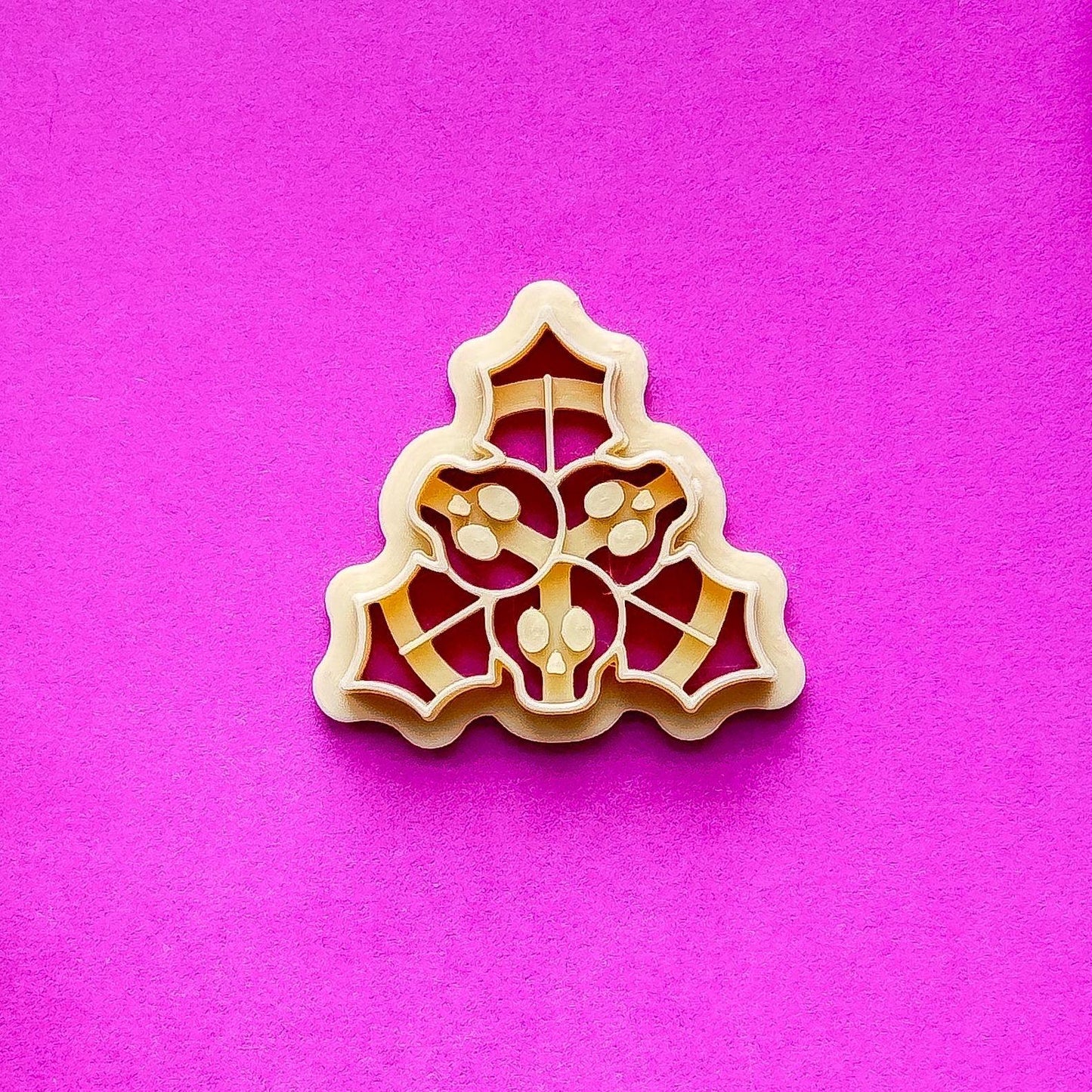 single beige holly clay cutter on purple contrasting background.