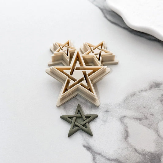 Pentagram star polymer clay cutter in beige material with green sample clay piece showing result of imprint embossing.