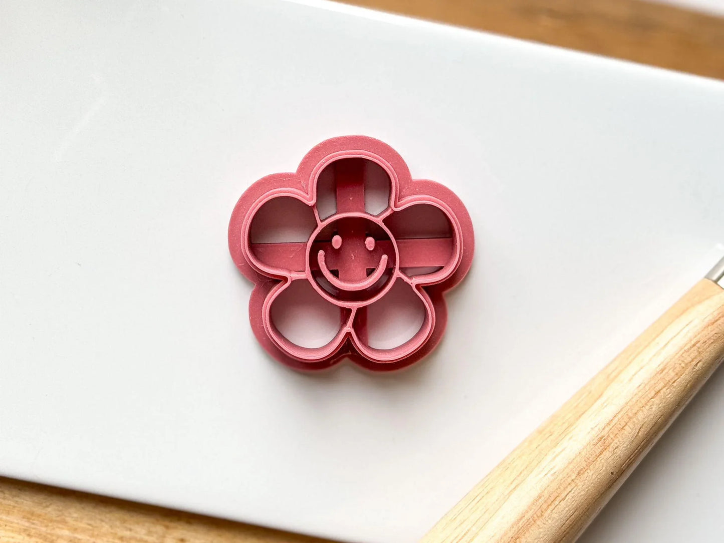 Close up of pink smiley face daisy polymer clay cutter