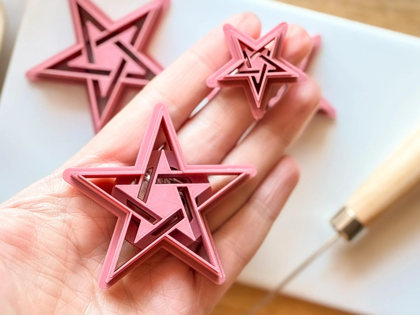 Pentagram star clay cutter in hand for scale
