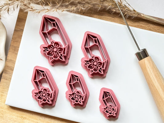 Crystal shaped polymer clay cutter with flower imprint detail on white tile