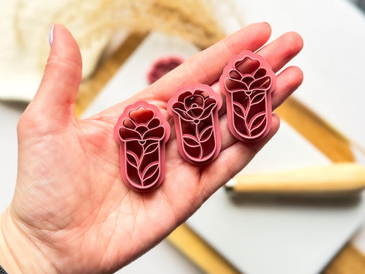 set of three clay cutters in floral stained glass style held in hand for scale