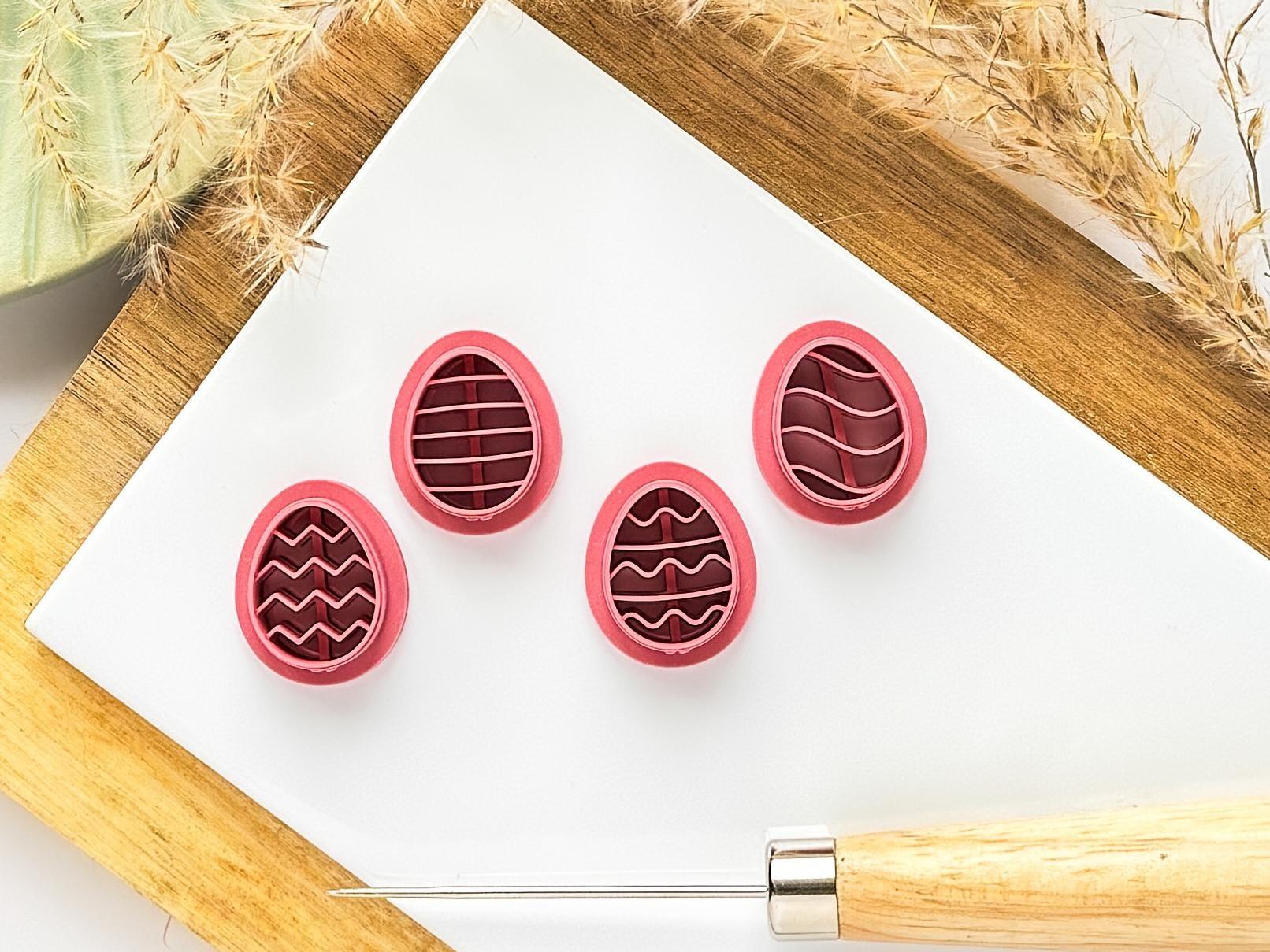 Easter egg clay cutter set in dark pink on white baking tile. Each egg features a different pattern from zigzag lines to wavy lines.