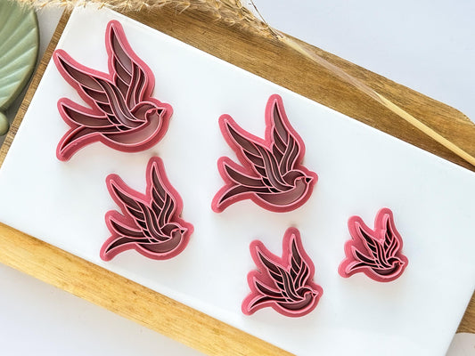All sizes of swallow bird tattoo sytle polymer clay cutter on a white tile