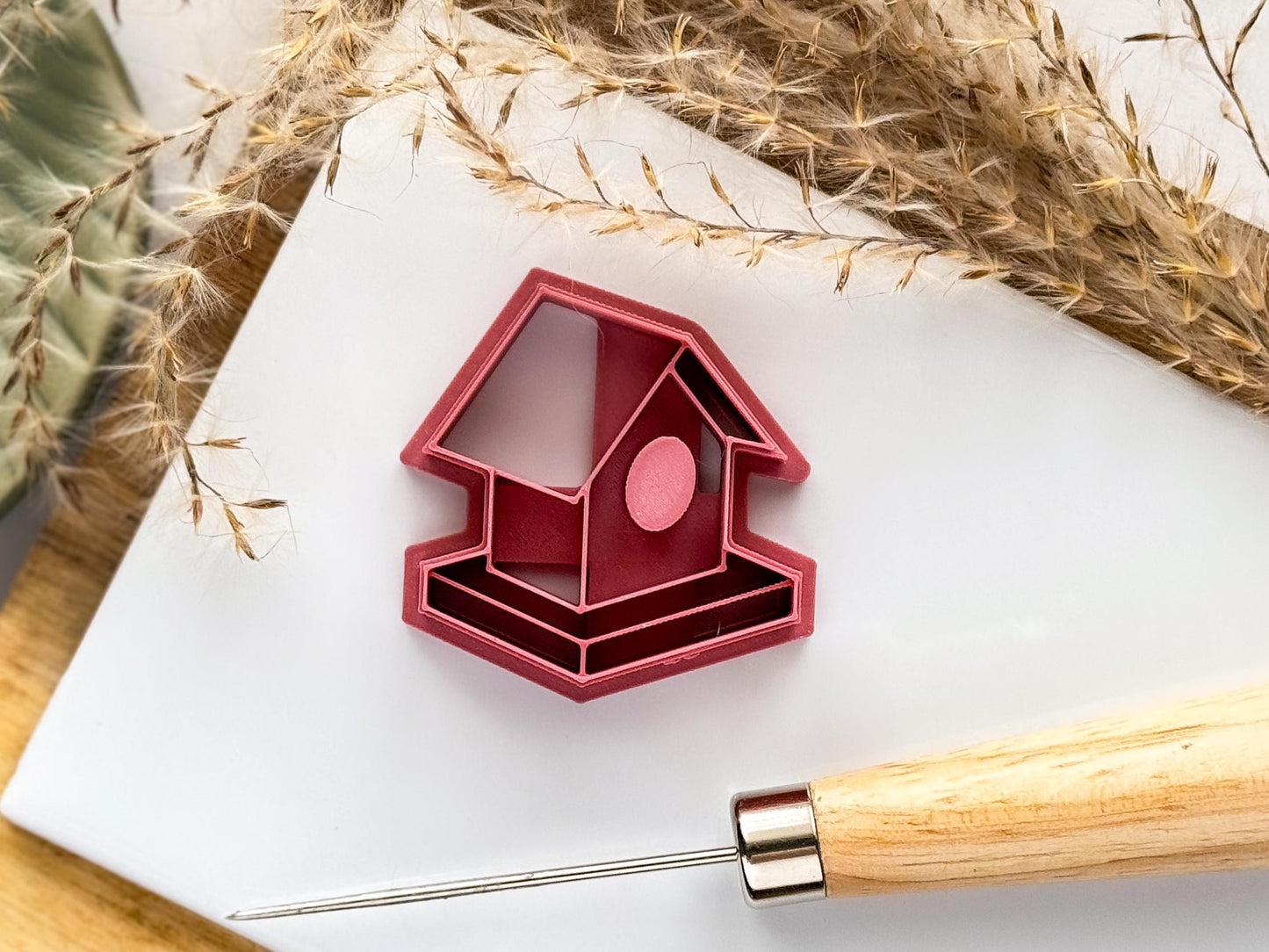 Single bird house bird table clay cutter on a white tile