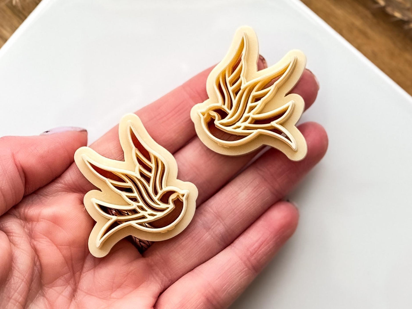 Beige sparrow cutters in hand for scale
