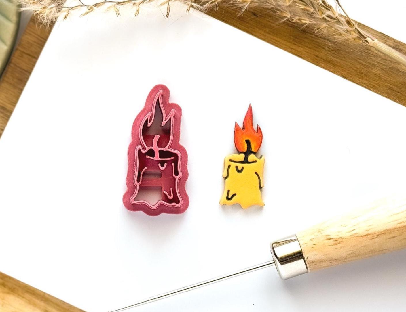 Candle and flame shapes clay cutter on a white tile