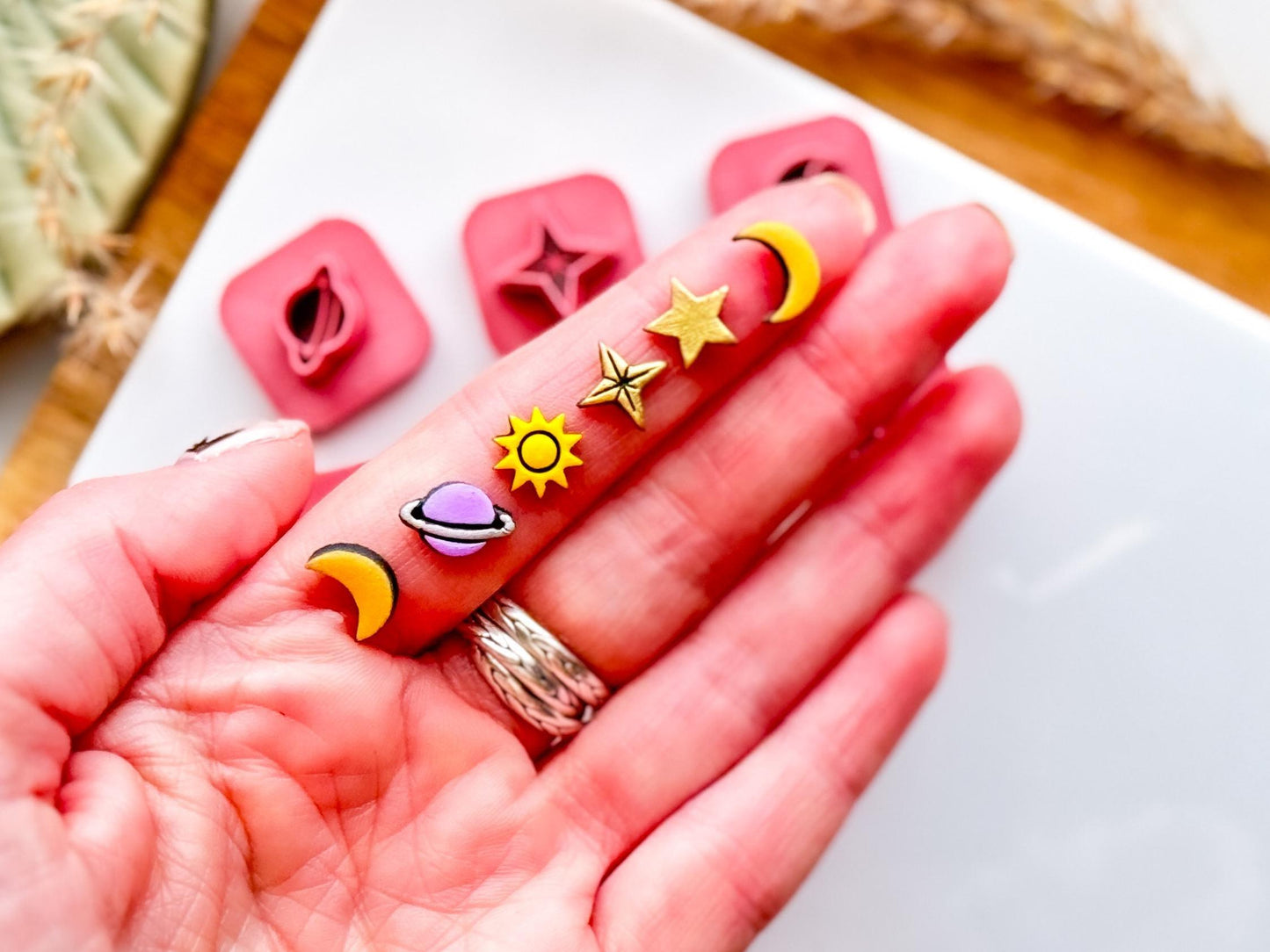 Mini galaxy polymer clay cut out shapes in hand