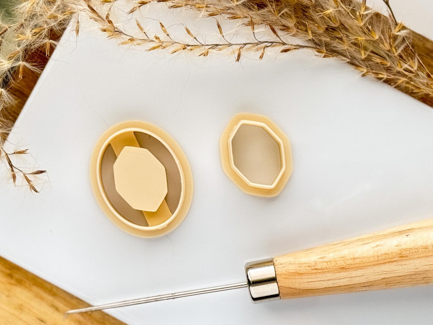 Beige coloured oval polymer clay cutter with embossing center and gemstone shaped inlay cutter