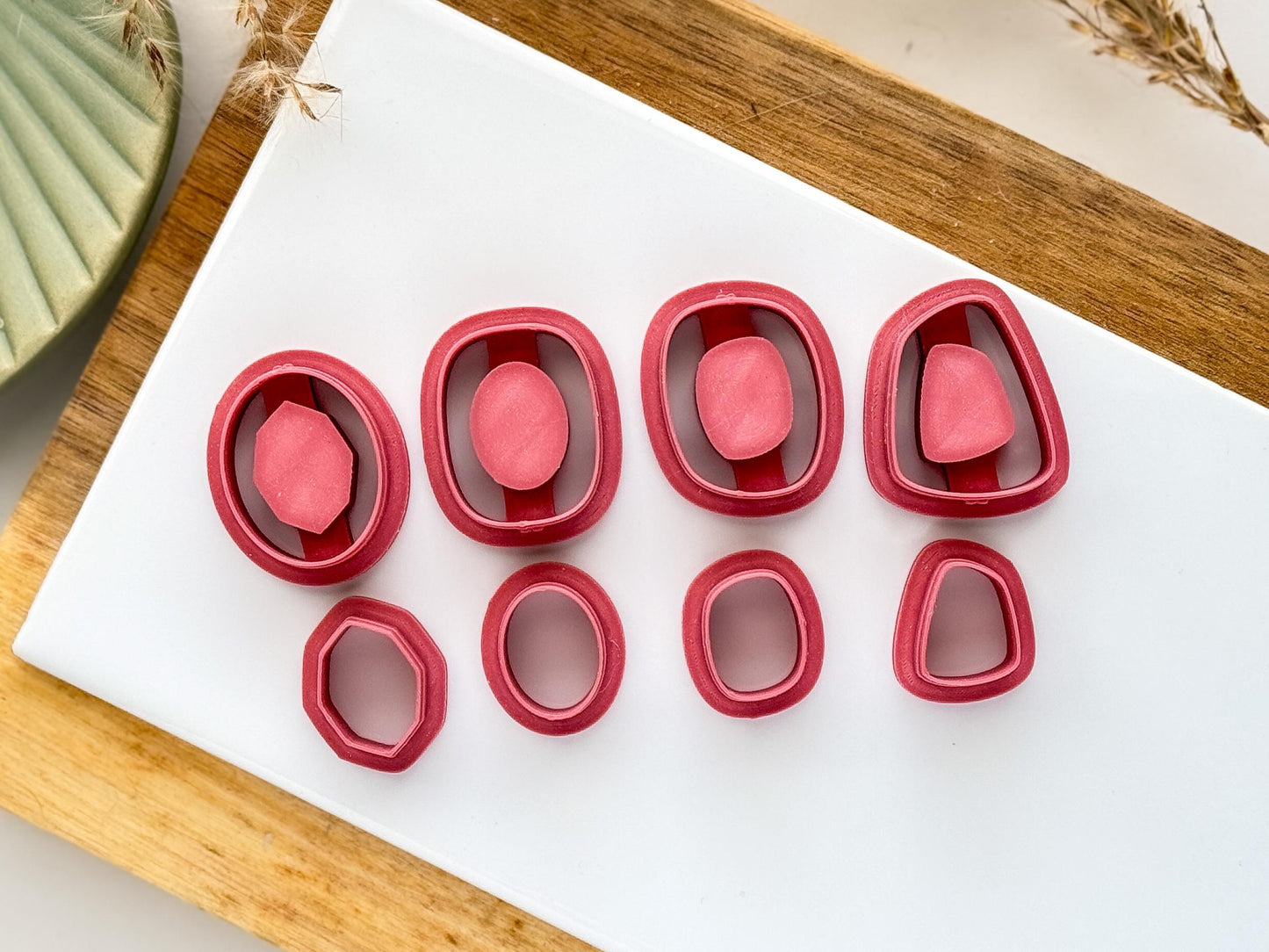 larger sizes of 8 pack inlay clay cutters on a white cermaic tile and wooded block