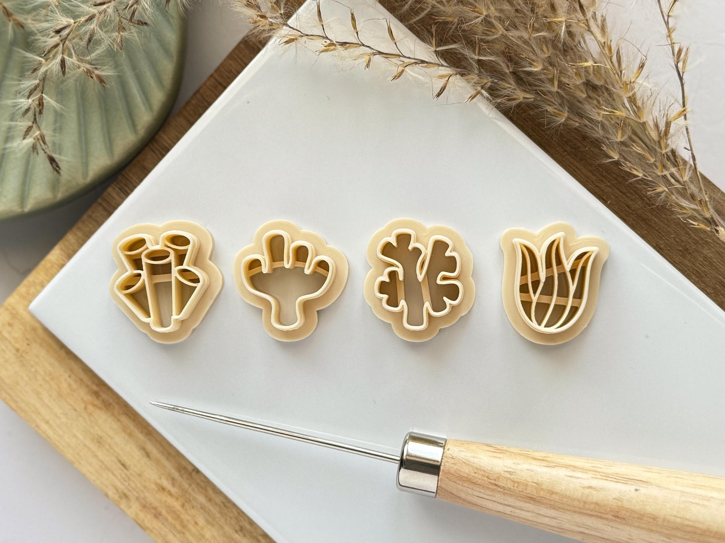 Beige polymer clay cutters in coral and seaweed seagrass shapes for making clay earrings.