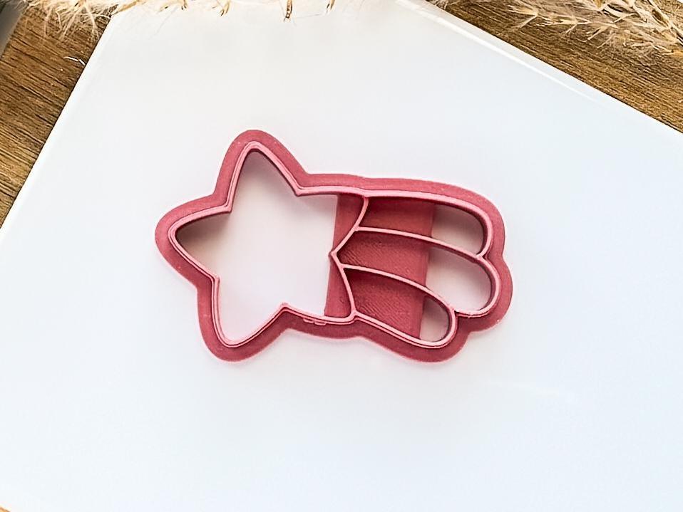 pink falling star polymer clay cutter on a white background