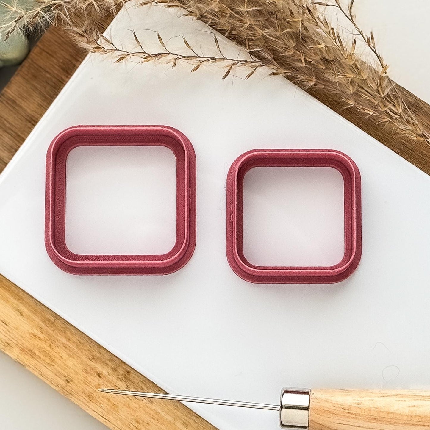 two sizes of rounded corner square clay cutters in dark pink