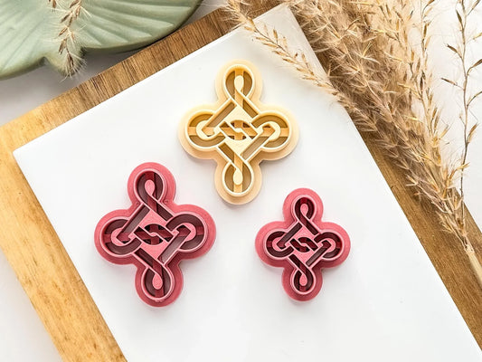 Different sizes of celtic knot polymer clay cutter with debossing sections to create a raised knot effect in clay