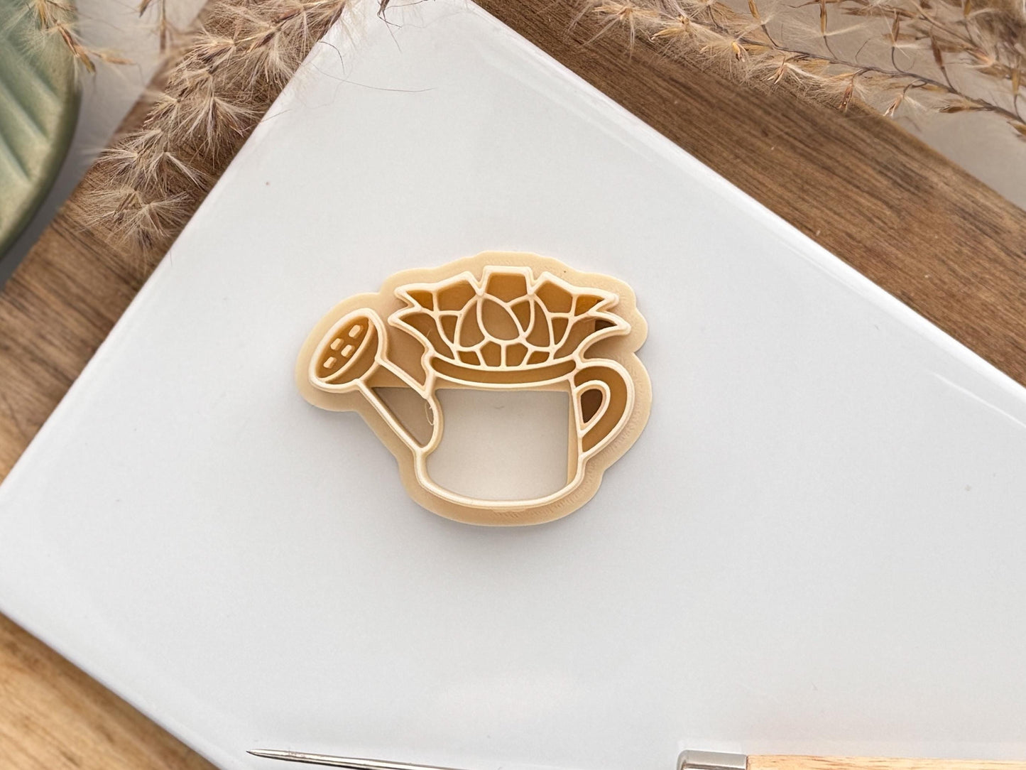 beige floral watering can clay cutter