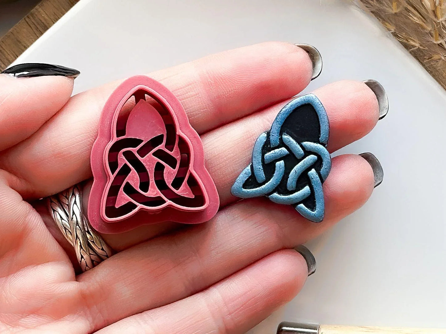 celtic triangle clay cutter with entwined knot strings in hand for scale