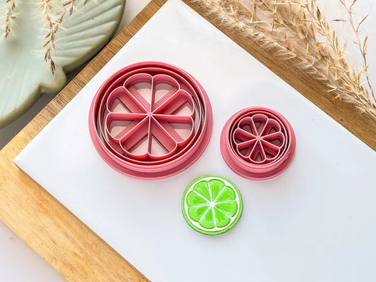 Polymer clay cutter in the shape of a circular slice of lime with stamped segment details