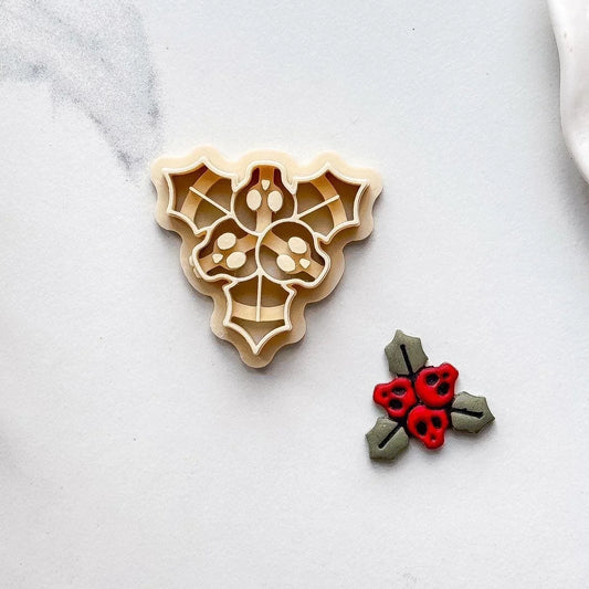 Single beige spooky Christmas cutter for polymer clay with sample piece on marble background. Alternative gothic Christmas clay molds.