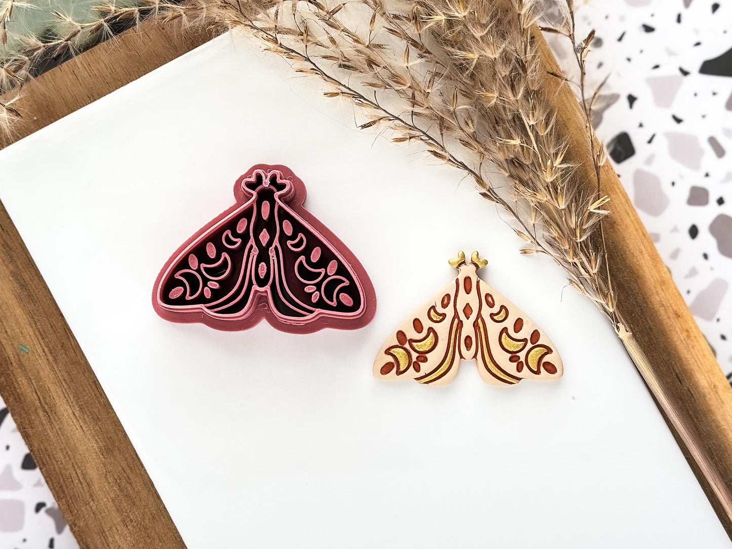 Boho sytle moth polymer clay cutter in dark pink colour with beige cut out clay shape