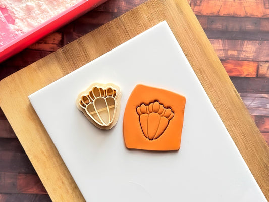 Orange polymer clay slab that has been cut with the beige triple carrot clay cutter.