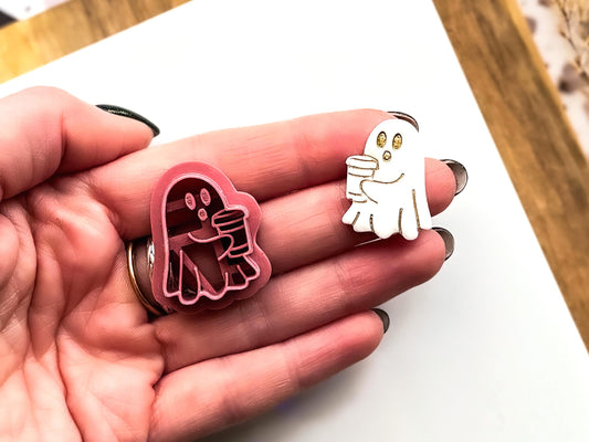 Hand holding ghost shaped polymer clay cutter with sample cut-out for earring making