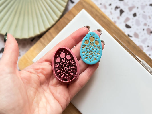 Boho egg shaped cutter and polymer clay cut out at 4 cm size being held in an open hand for scale