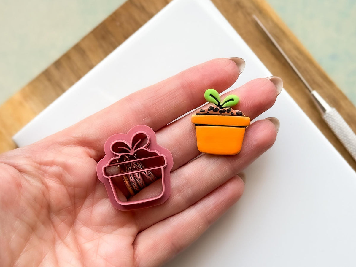 Flower pot clay cutter and sample polymer clay cut out being held in a hand for scale. The image shows the 2.5cm version.