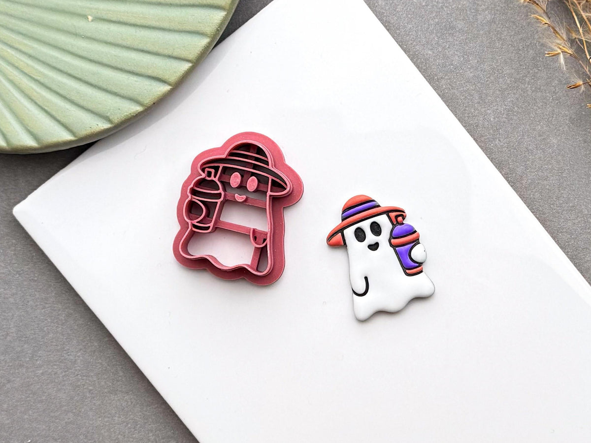Cute summer ghost polymer clay cutter displayed beside a finished ghost earring with a striped smoothie cup.