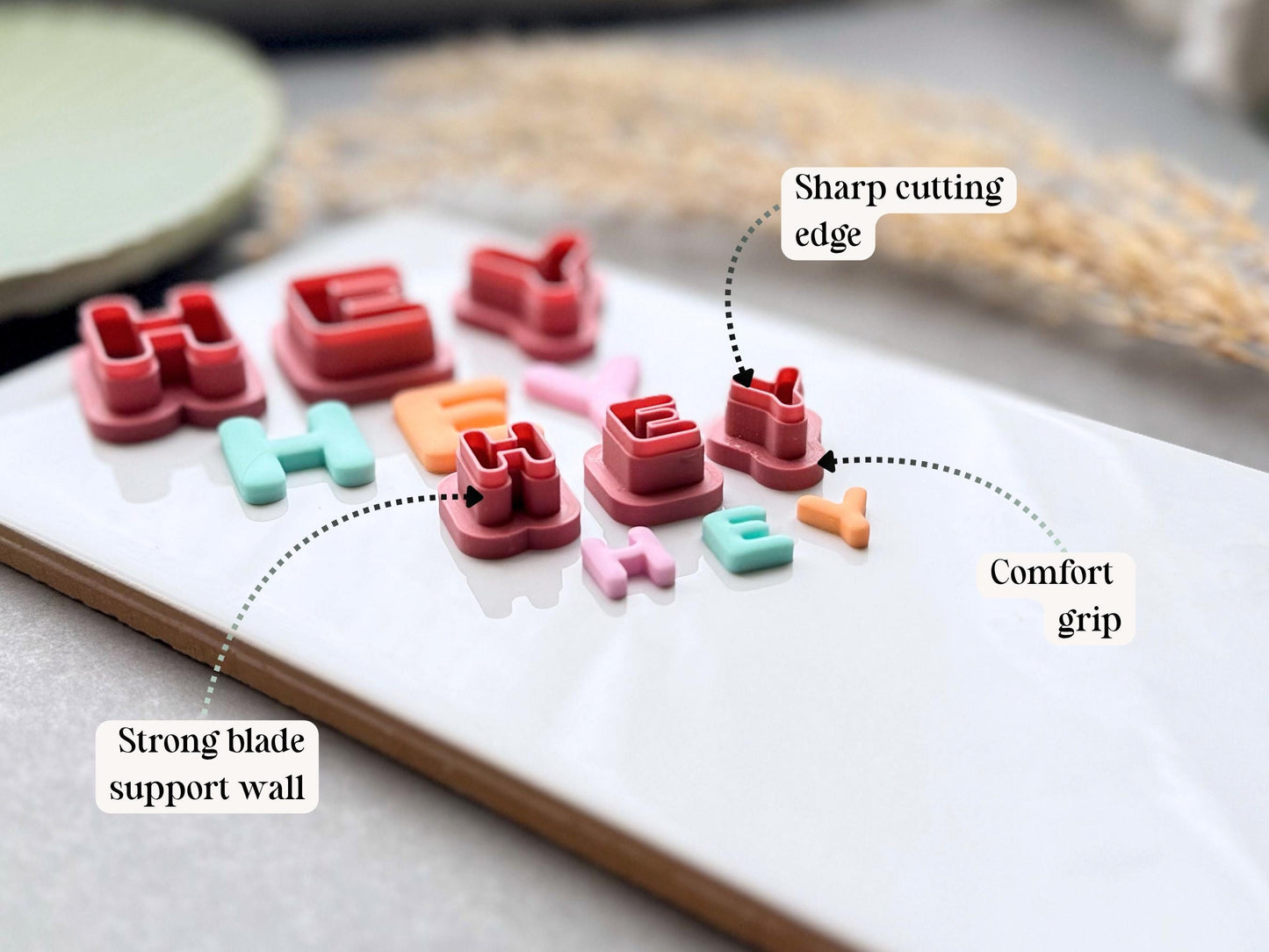 Diagram showing the sharp cutting edge, strong blade support wall and comfort grip of uppercase alphabet polymer clay letter cutters.
