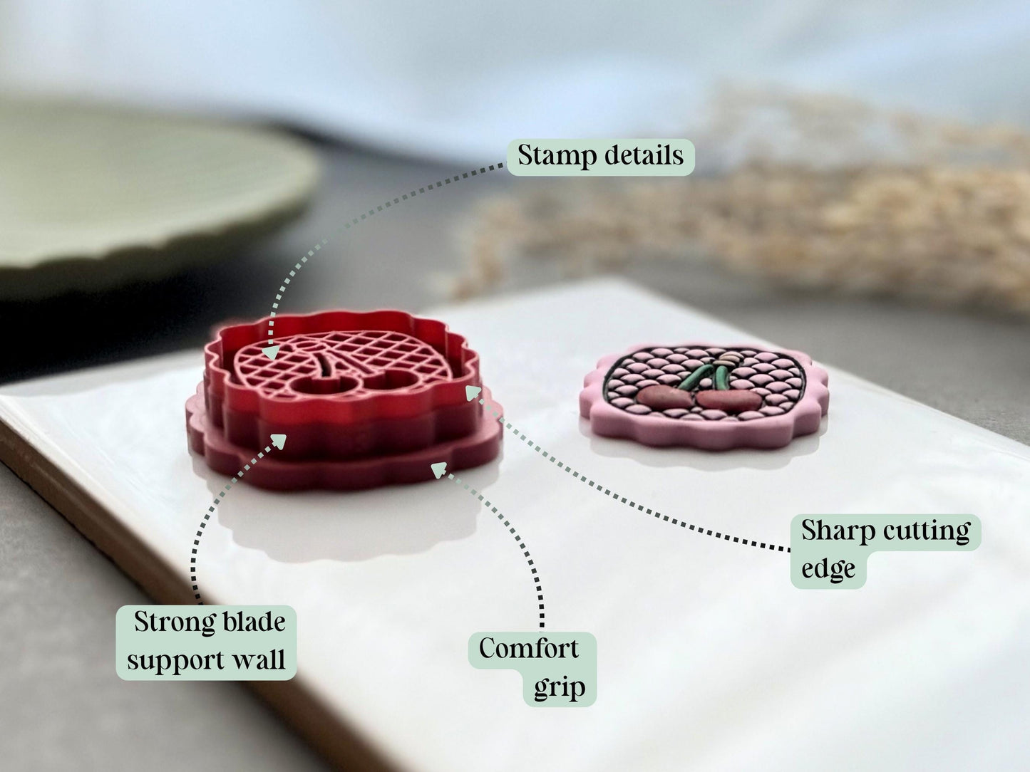 Feature graphic highlighting the cherry polymer clay cutter's detailed stamp imprint, sharp cutting edge, strong blade support wall and comfortable grip, shown beside the matching finished clay embellishment.
