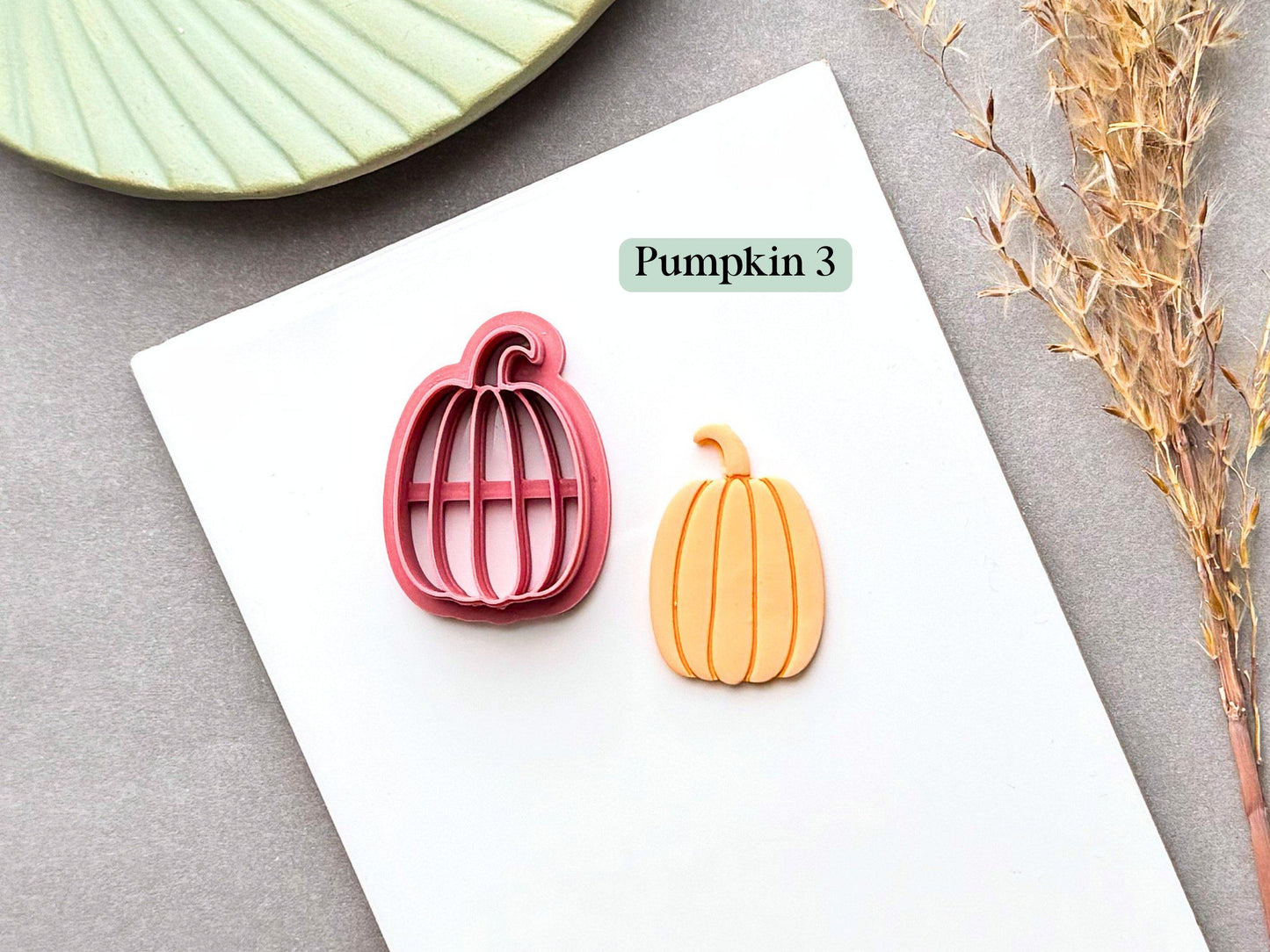 Pumpkin polymer clay cutter featuring a tall, rounded pumpkin shape with a curled stem, shown alongside a finished orange pumpkin clay piece.