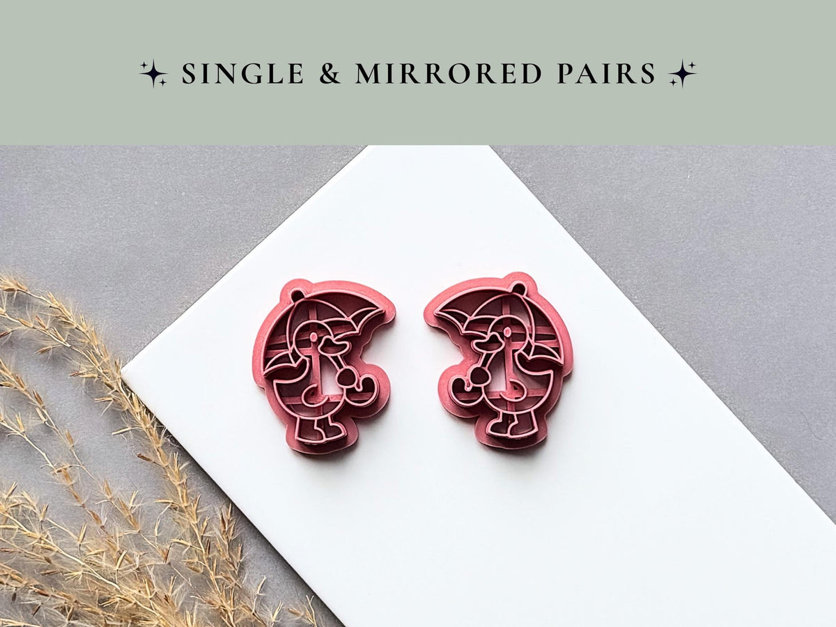Single and mirrored umbrella character polymer clay cutters displayed side by side, featuring a character holding a curved umbrella with detailed internal stamp lines on a white tile.