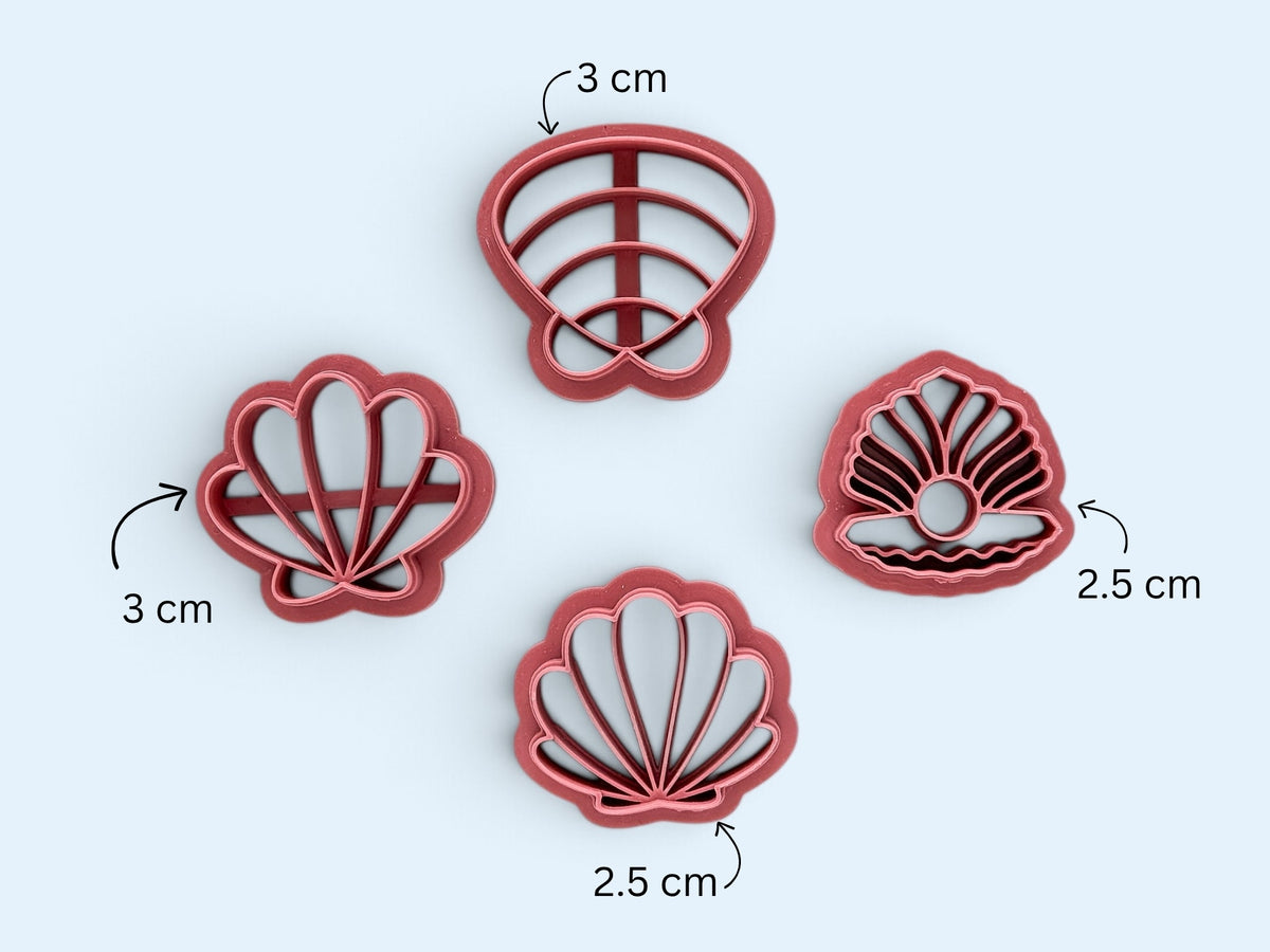 Fourpink seashell-shaped clay cutters arranged on a light blue background, with size callouts showing 3 cm and 2.5 cm measurements.