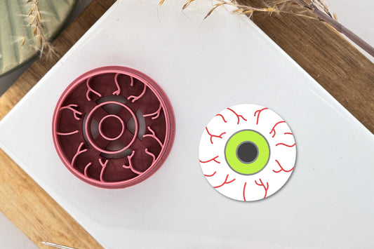 Bloodshot eyeball shaped clay cutter with vein, iris and pupil stamp imprint lines.