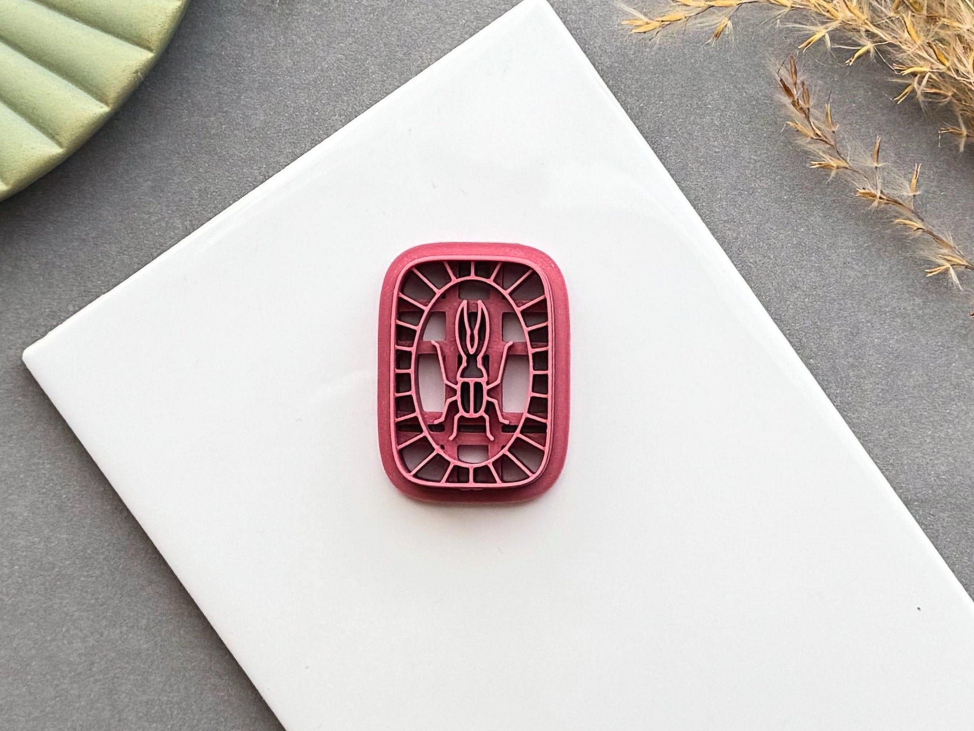 Beetle polymer clay cutter featuring a simple beetle design framed by a decorative segmented border, shown on a white display tile.