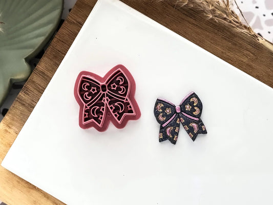 Celestial themed ribbon bow shaped clay cutter with moon and star stamp details