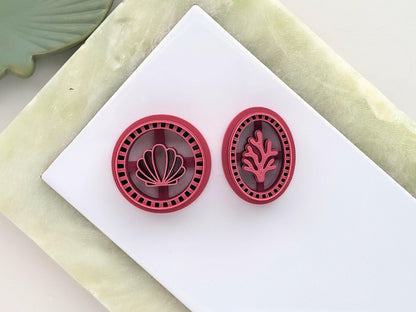 Circular polymer clay cutter with a calm shell stamp design and oval cutter with a coral stamp design. Both feature a frame edge with squares.