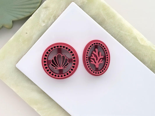 Circular polymer clay cutter with a calm shell stamp design and oval cutter with a coral stamp design. Both feature a frame edge with squares.