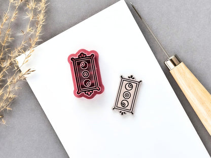 Rectangle frame polymer clay cutter featuring three eyeball details arranged vertically within an ornate rectangular border, shown beside a matching finished cream polymer clay cut-out. Pink 3D-printed cutter displayed on a white surface.