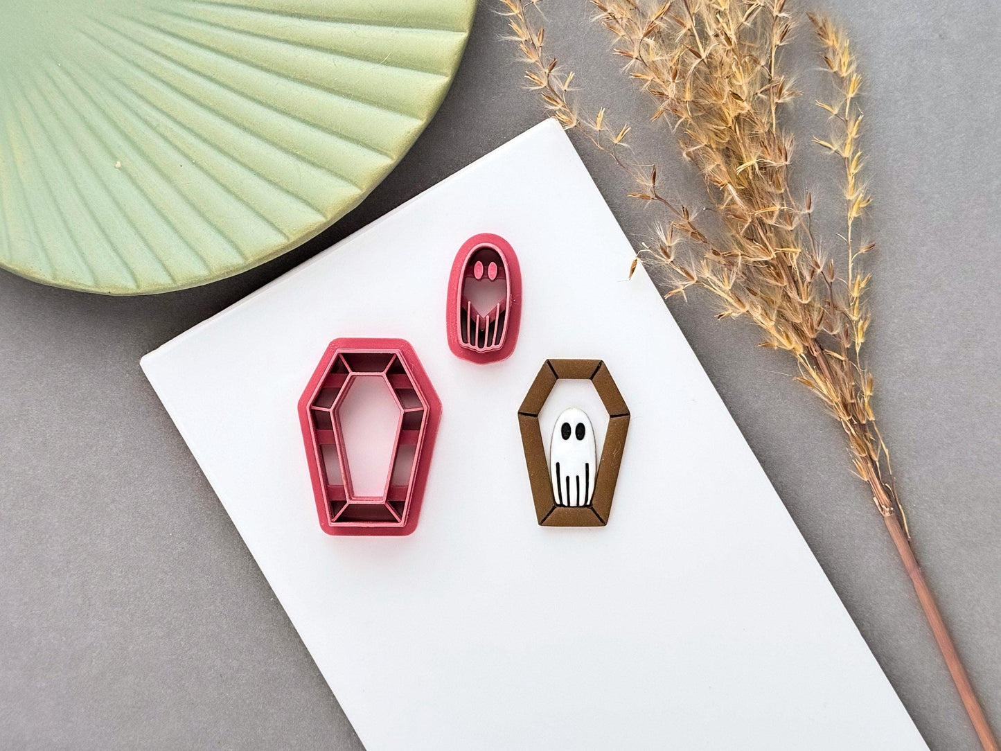 Ghost in coffin polymer clay cutter set with matching ghost stamp, shown alongside a finished clay ghost embellishment in a coffin-shaped frame. Perfect for Halloween, spooky, gothic and cute ghost-themed jewellery and craft projects.