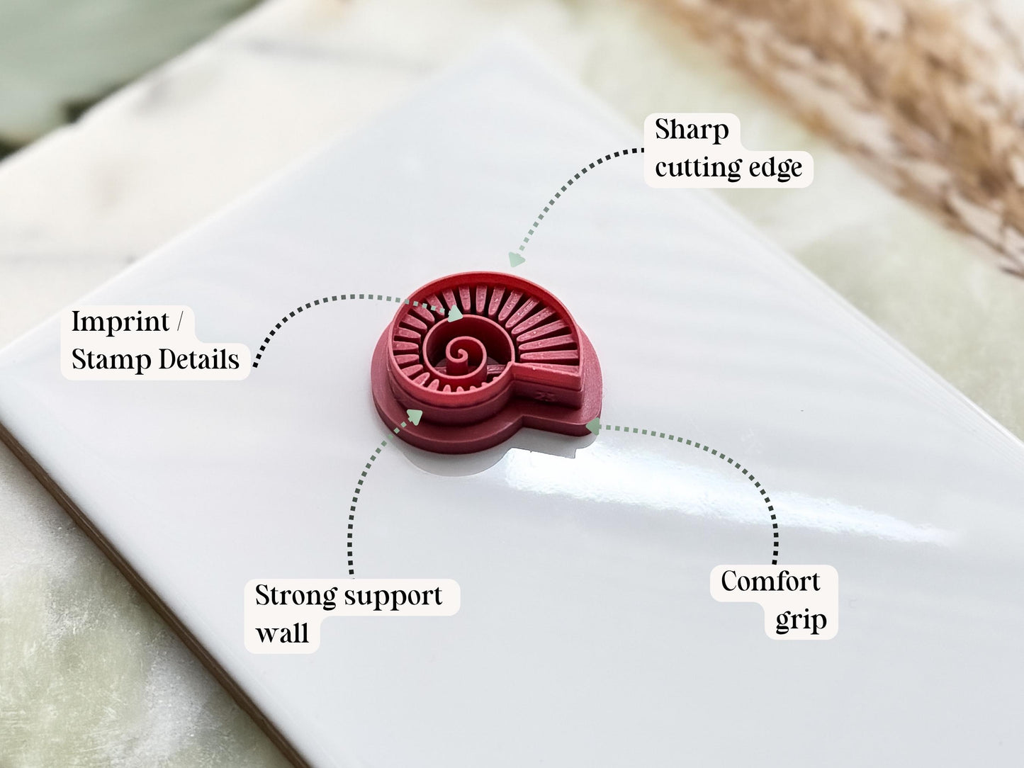 Fossil seashell clay cutter key features diagram detailing the sharp cutting edge, embossing details, support wall and comfort grip.