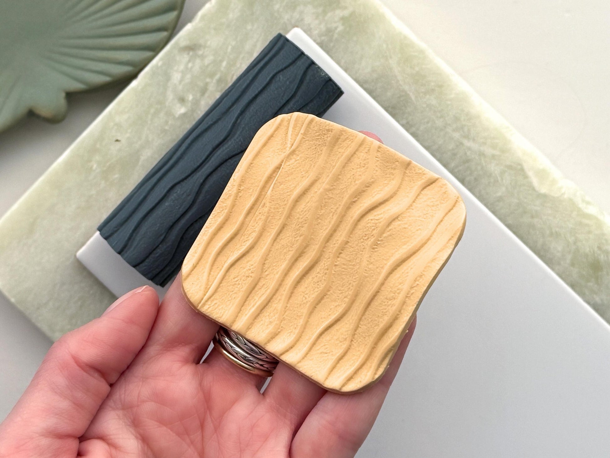 Close up of polymer clay square with sand texture