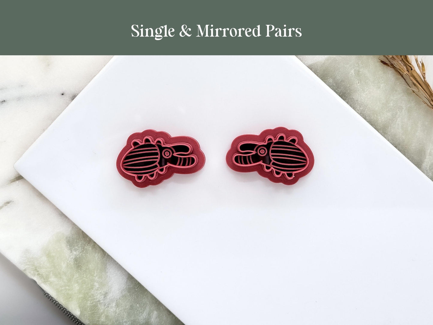 Pair of mirrored cartoon style stag beetle clay cutters in pink. 