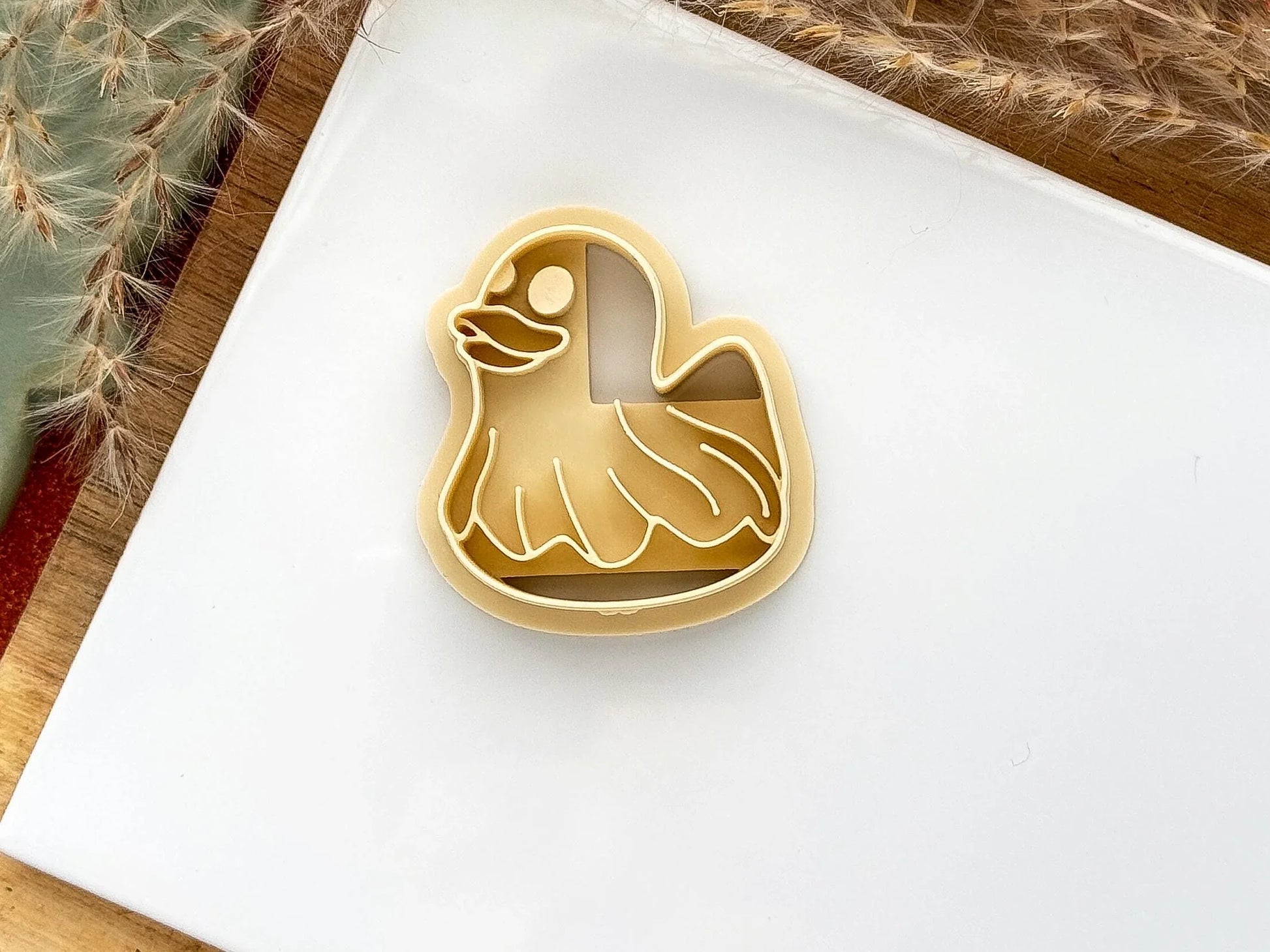 Beige coloured duck polymer clay cutter wearing a ghost sheet 