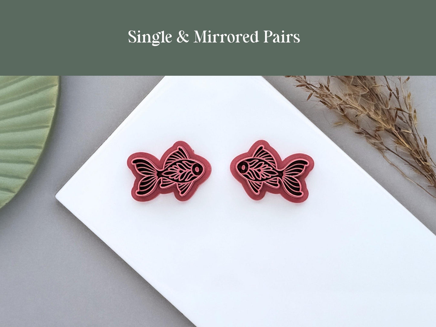 Pair of mirrored ornamental fish polymer clay cutters displayed on a white ceramic tile with the text 'Single & Mirrored Pairs'.