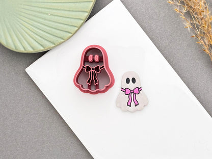 Cute ghost with a pink bow polymer clay cutter beside a finished ghost earring with a pink ribbon bow.