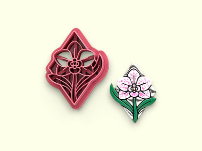 A diamond shaped orchid clay cutter shown next to its matching polymere clay sample earring. 