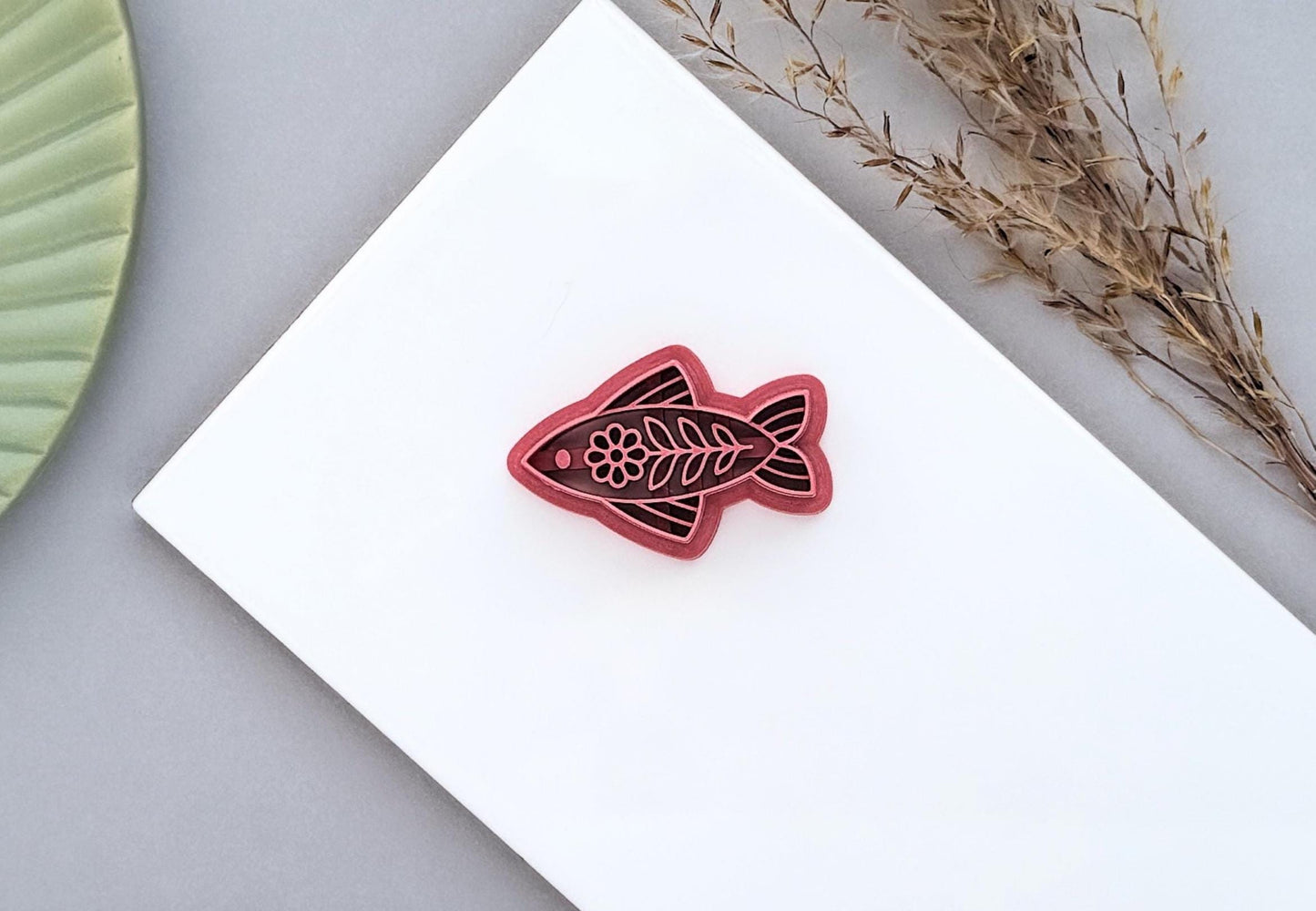 Floral folk art style fish-shaped polymer clay cutter with intricate stamp details for making earrings and jewellery.